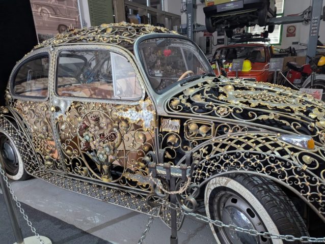 volkswagen-beetle-fier-forjat-muzeu-auto-skradin Volkswagen Beetle unicat, realizat manual din fier forjat, decorat cu motive florale și detalii aurite, expus în muzeul auto din Skradin, Croația.